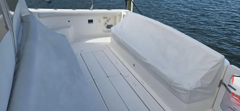 Slide: The Image of 2004 Tiara Yachts 5200 Sovran deck with covered seating, overlooking calm water. - 8