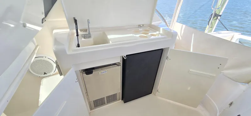 Slide: The Image of 2004 Tiara Yachts 5200 Sovran cockpit with sink, mini fridge, and storage. - 9