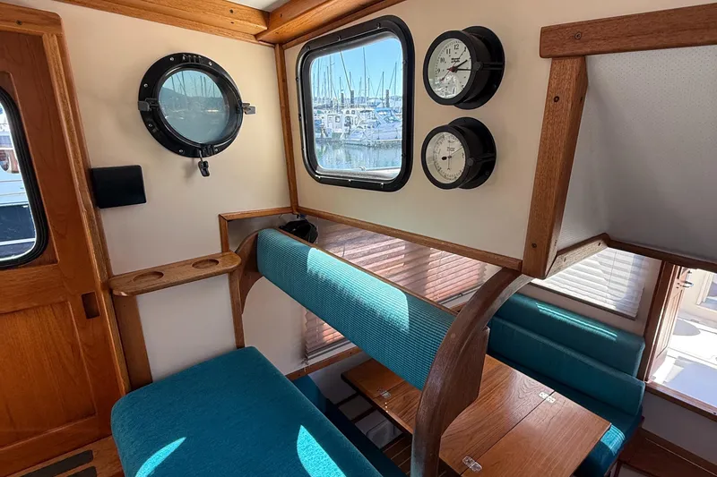Slide: The Image of Cozy interior of a 1997 Nordic Tug 26 with teal seating and nautical instruments. - 10