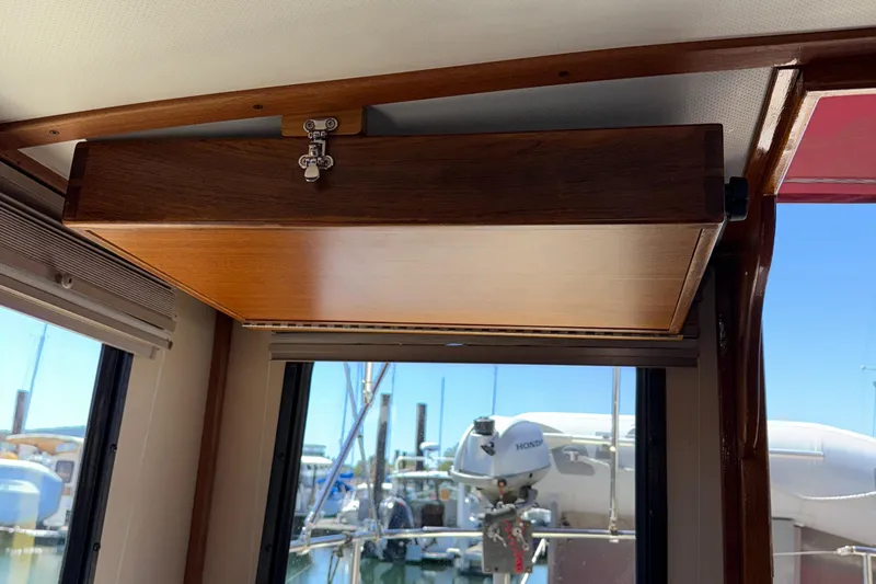 Slide: The Image of Interior of a 1997 Nordic Tug 26, featuring wooden cabinetry and marina view. - 16