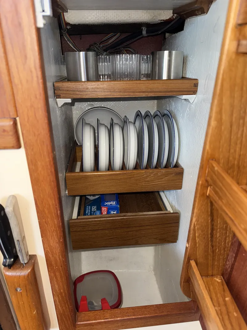 Slide: The Image of Wooden cabinet with dishes and storage in a 1997 Nordic Tug 26 boat. - 19
