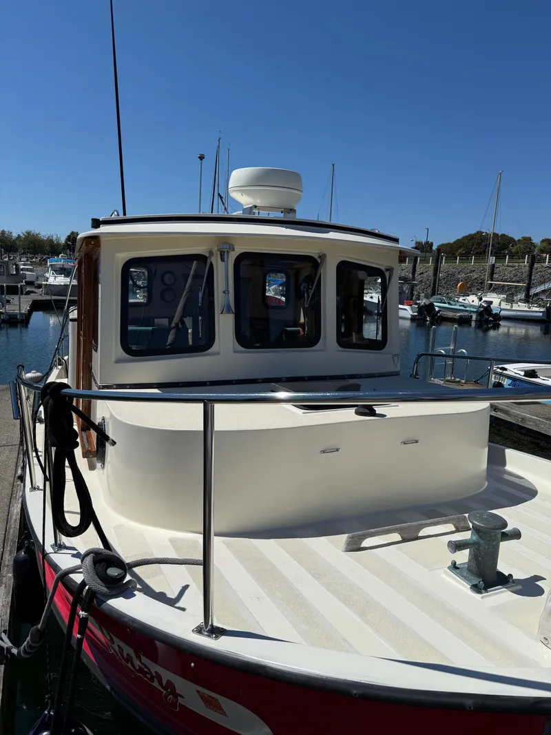 Slide: The Image of 1997 Nordic Tug 26 docked at a marina under clear blue skies. - 2