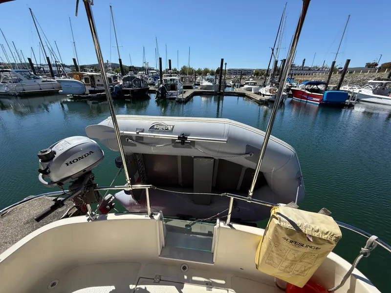Slide: The Image of 1997 Nordic Tug 26 at marina with inflatable boat and Honda outboard motor. - 3