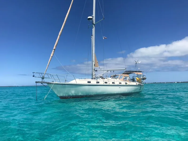 The Image of Sailboat Caliber 40LRC 2003 anchored in clear turquoise waters under a bright blue sky. - 0