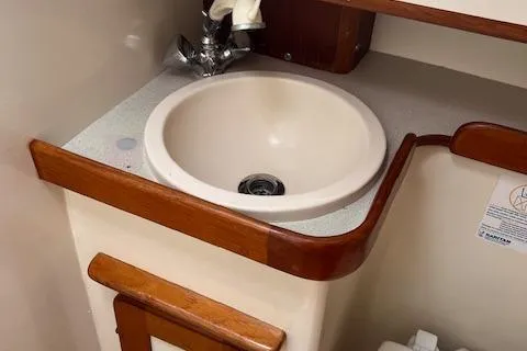 Slide: The Image of Small bathroom sink with wooden trim in a 2003 Caliber 40LRC boat. - 14