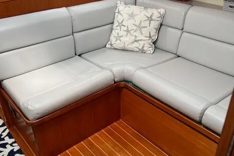 Slide: The Image of 2003 Caliber 40LRC yacht interior with gray leather seating and starfish-patterned pillow. - 17