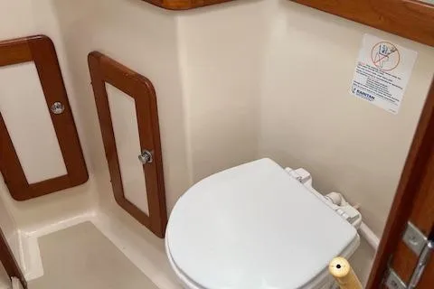 Slide: The Image of 2003 Caliber 40LRC boat bathroom with wooden accents and a white toilet. - 19
