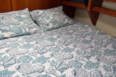 Slide: The Image of Nautical-themed bedding in a 2003 Caliber 40LRC cabin, featuring seashell and coral patterns. - 24