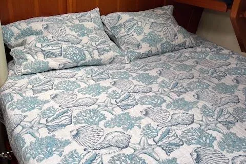 Slide: The Image of Nautical-themed bedding in a 2003 Caliber 40LRC cabin, featuring seashell and coral patterns. - 25