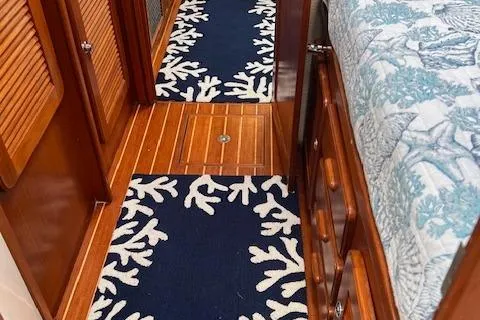 Slide: The Image of Caliber 40LRC 2003 yacht interior with wooden flooring and nautical-themed rugs. - 26