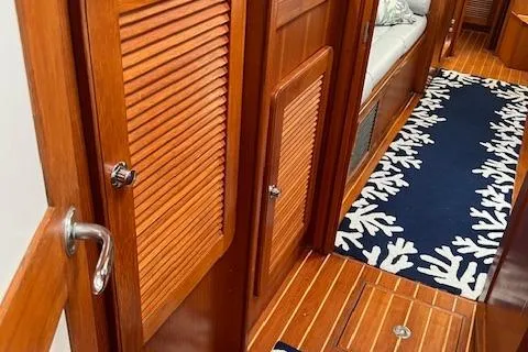 Slide: The Image of Interior of 2003 Caliber 40LRC yacht with wooden doors and nautical-themed rug. - 27