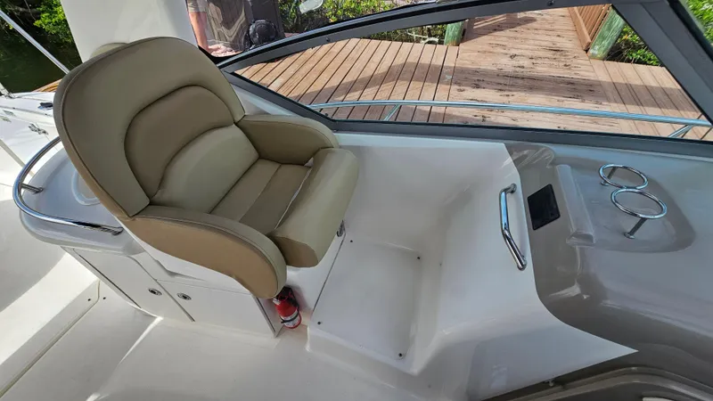 Slide: The Image of Captain's seat on 2007 Sea Ray 340 Sundancer boat, featuring beige upholstery and cup holders. - 17