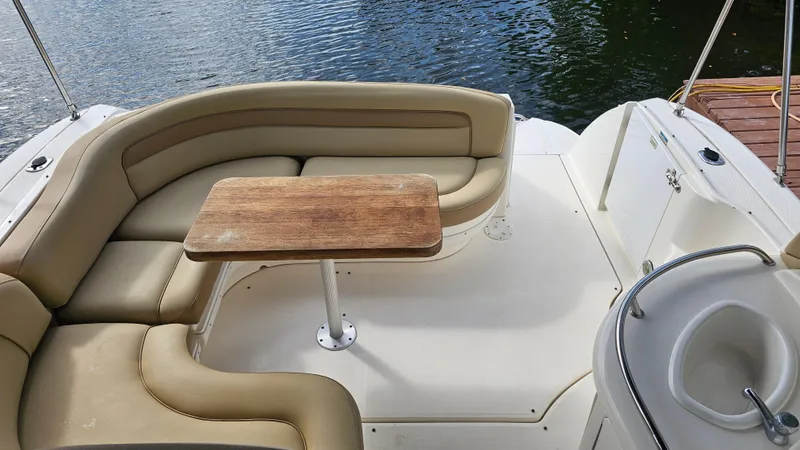 Slide: The Image of 2007 Sea Ray 340 Sundancer boat interior with beige seating and wooden table. - 19