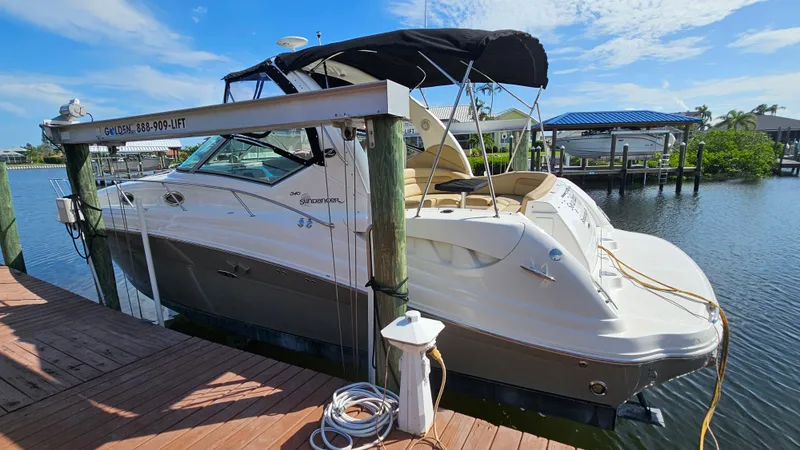 Slide: The Image of 2007 Sea Ray 340 Sundancer docked, featuring sleek design and spacious deck under sunny skies. - 2