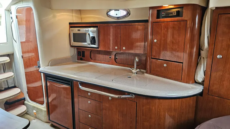 Slide: The Image of Luxurious 2007 Sea Ray 340 Sundancer yacht interior with kitchenette and wooden cabinetry. - 28