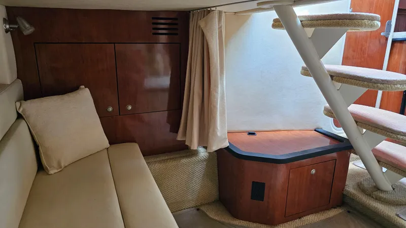 Slide: The Image of Interior of 2007 Sea Ray 340 Sundancer with beige seating and wooden cabinetry. - 32