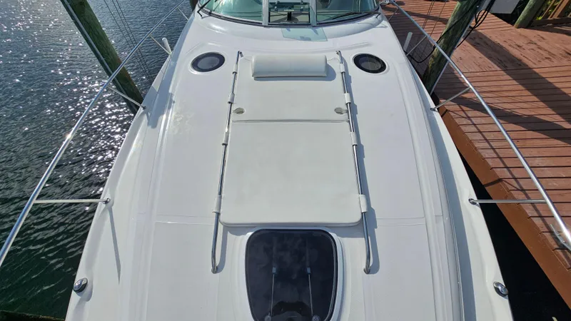 Slide: The Image of 2007 Sea Ray 340 Sundancer yacht deck with sun pad, docked by sparkling water. - 38
