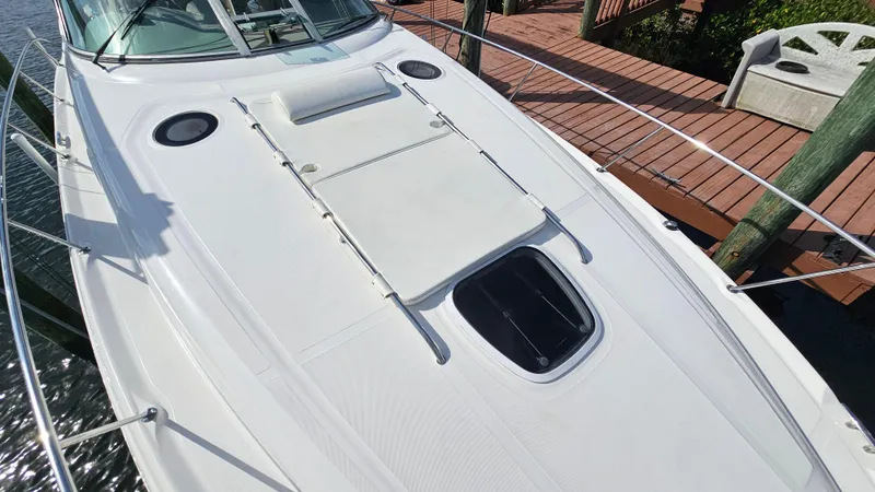 Slide: The Image of 2007 Sea Ray 340 Sundancer yacht deck with sunpad and hatch, docked by wooden pier. - 39