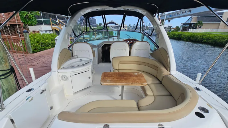 Slide: The Image of 2007 Sea Ray 340 Sundancer yacht interior with seating and table, docked by the water. - 5