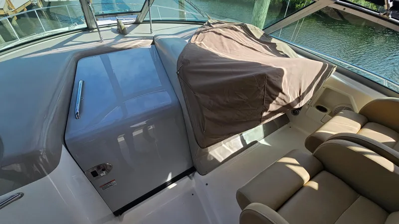 Slide: The Image of 2007 Sea Ray 340 Sundancer cockpit with covered dashboard and beige seating. - 6