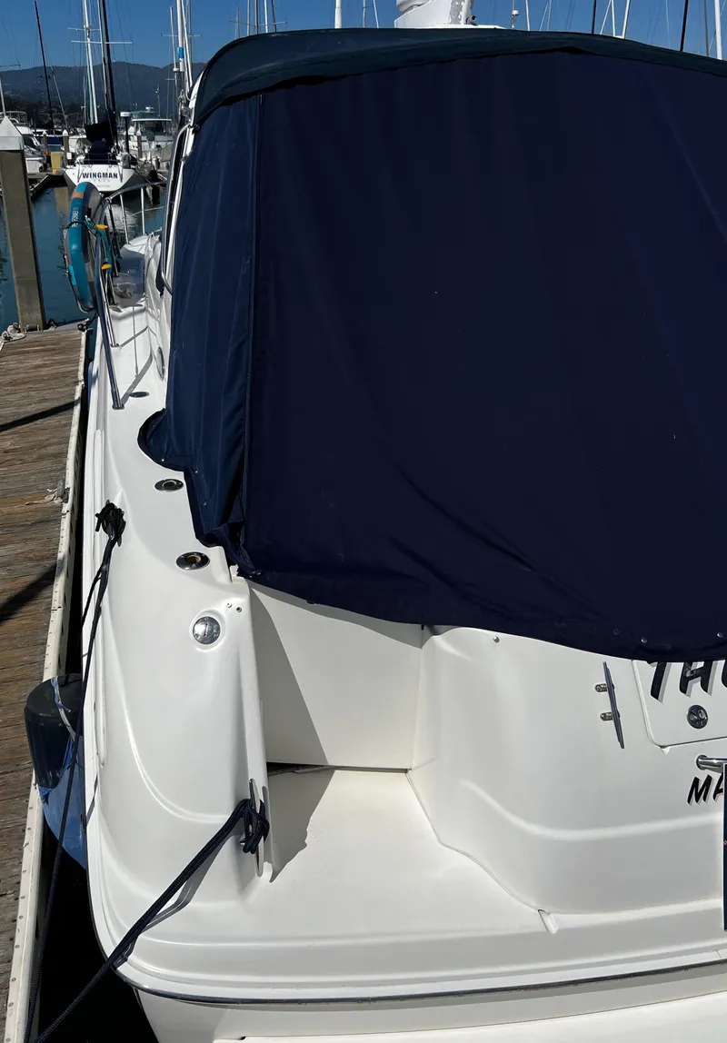 Slide: The Image of 2000 Sea Ray 380 Sundancer docked, featuring a navy blue cover. - 10