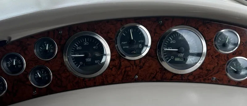 Slide: The Image of Dashboard of a 2000 Sea Ray 380 Sundancer with multiple gauges and wood paneling. - 14