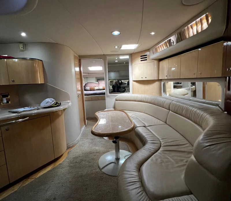 Slide: The Image of Interior of 2000 Sea Ray 380 Sundancer yacht with curved seating and kitchenette. - 19