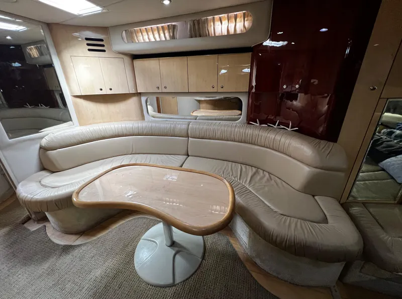 Slide: The Image of Luxurious interior of 2000 Sea Ray 380 Sundancer with curved seating and wooden table. - 20