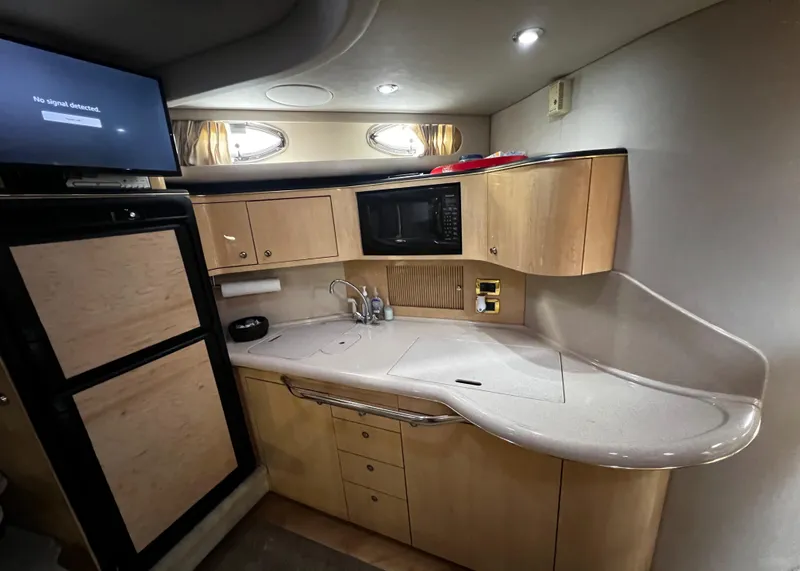 Slide: The Image of Interior of a 2000 Sea Ray 380 Sundancer yacht kitchen with modern amenities. - 23