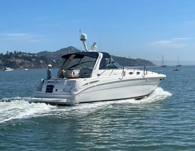 Slide: The Image of 2000 Sea Ray 380 Sundancer cruising on a calm sea with distant hills. - 5
