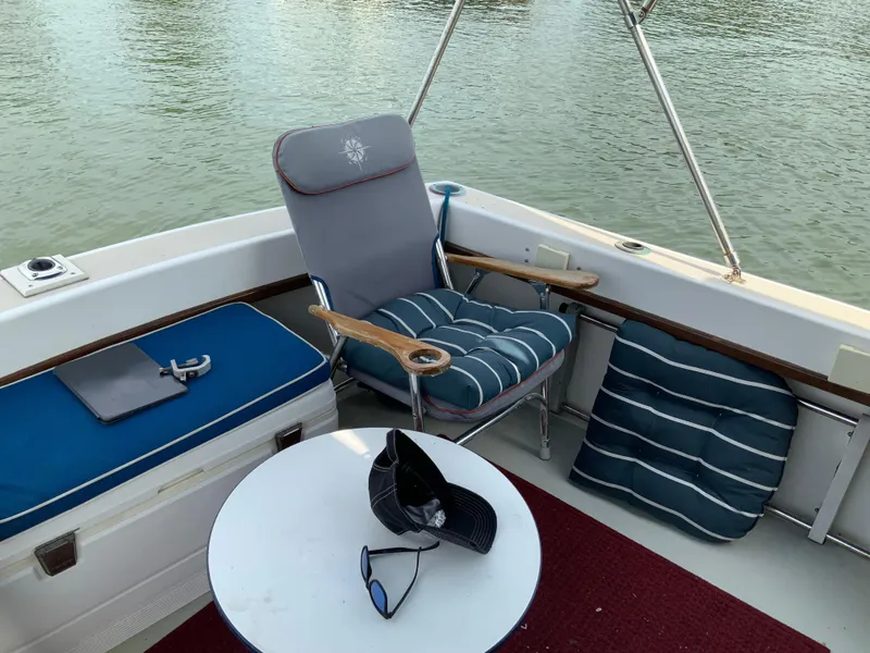 Slide: The Image of 1986 Cape Dory 26 Fly boat interior with cushioned seating and table on calm water. - 10