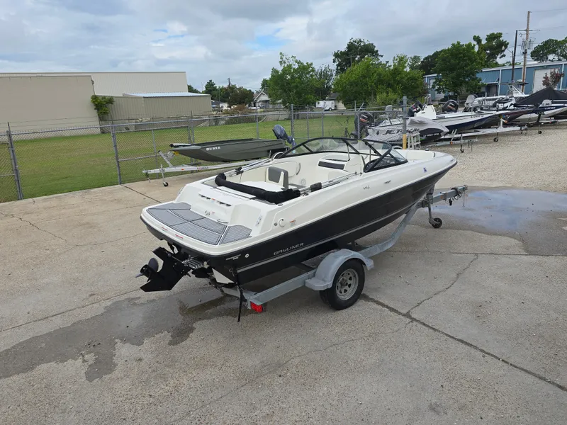 Slide: The Image of 2018 Bayliner VR4 Bowrider I/O on trailer, parked outdoors near other boats. - 6