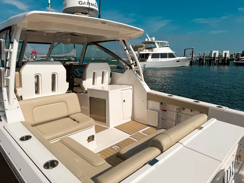 Slide: The Image of 2018 Pursuit DC 325 Dual Console boat docked, featuring spacious seating and modern design. - 10