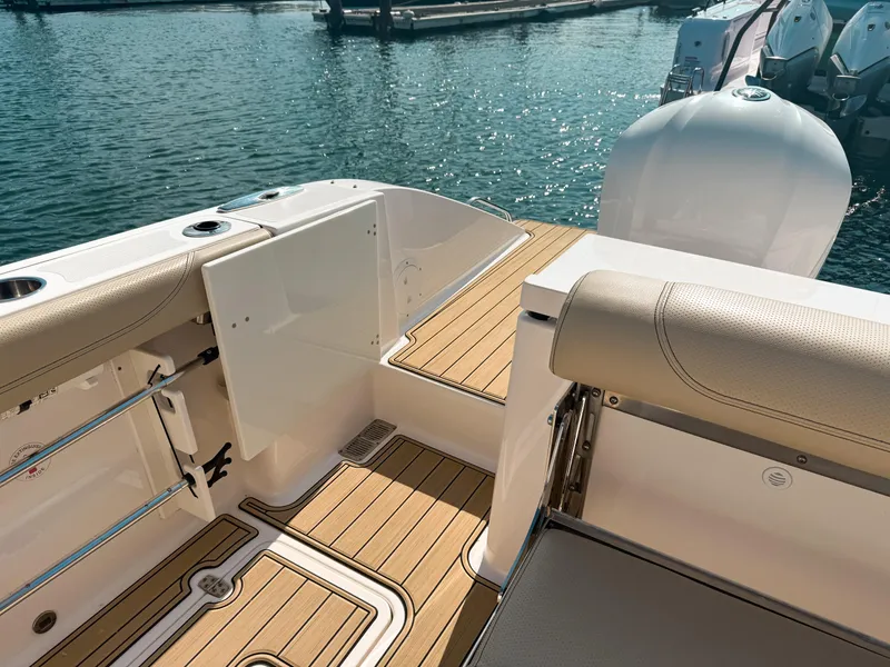 Slide: The Image of 2018 Pursuit DC 325 Dual Console boat with teak flooring, docked by the water. - 14