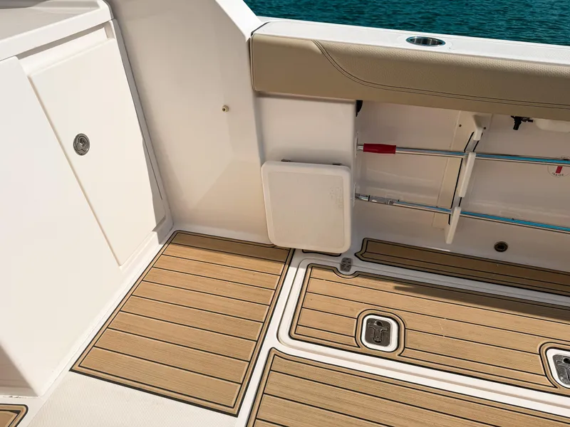Slide: The Image of 2018 Pursuit DC 325 Dual Console boat interior with teak flooring and storage compartments. - 18