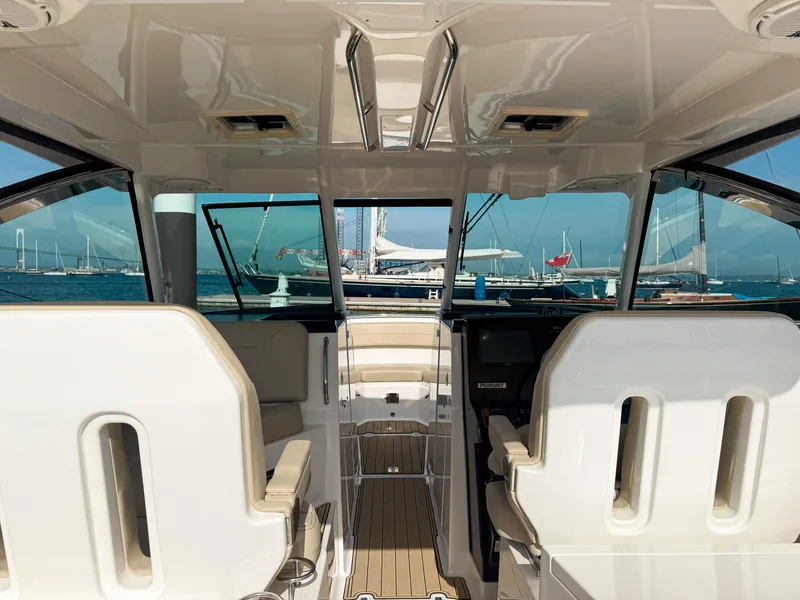 Slide: The Image of 2018 Pursuit DC 325 Dual Console interior with ocean view and docked boats. - 20