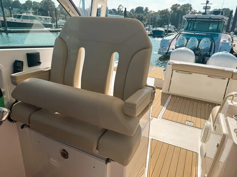 Slide: The Image of 2018 Pursuit DC 325 Dual Console boat interior with luxurious seating and teak flooring. - 24