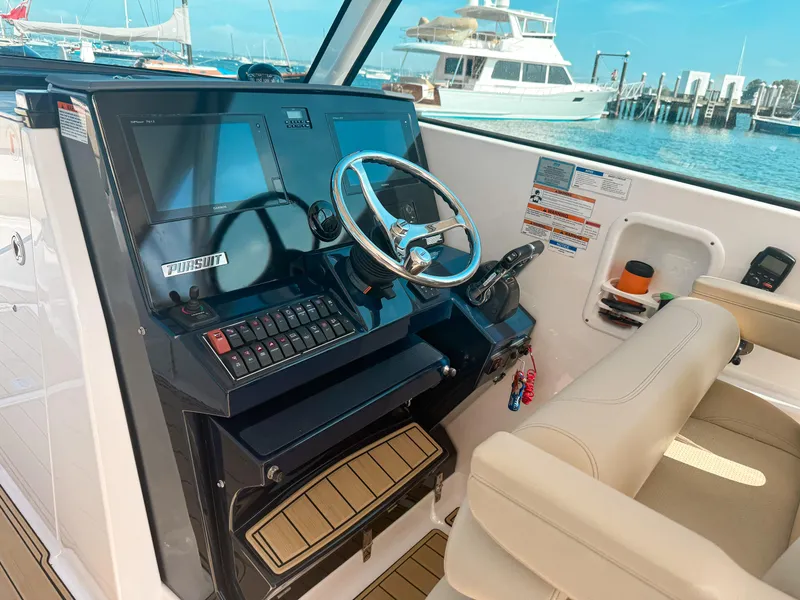Slide: The Image of 2018 Pursuit DC 325 Dual Console boat helm with steering wheel and navigation screens. - 25