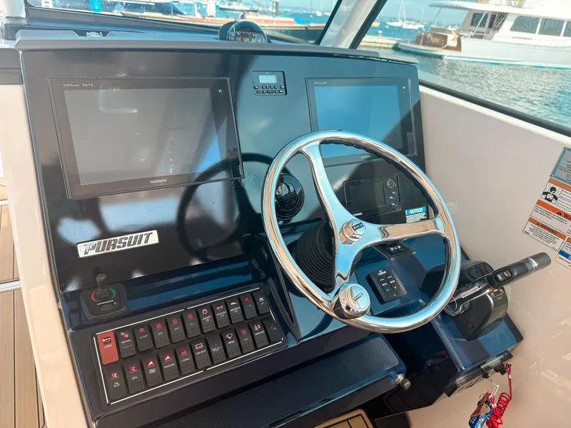Slide: The Image of 2018 Pursuit DC 325 Dual Console helm with Garmin displays and steering wheel. - 26