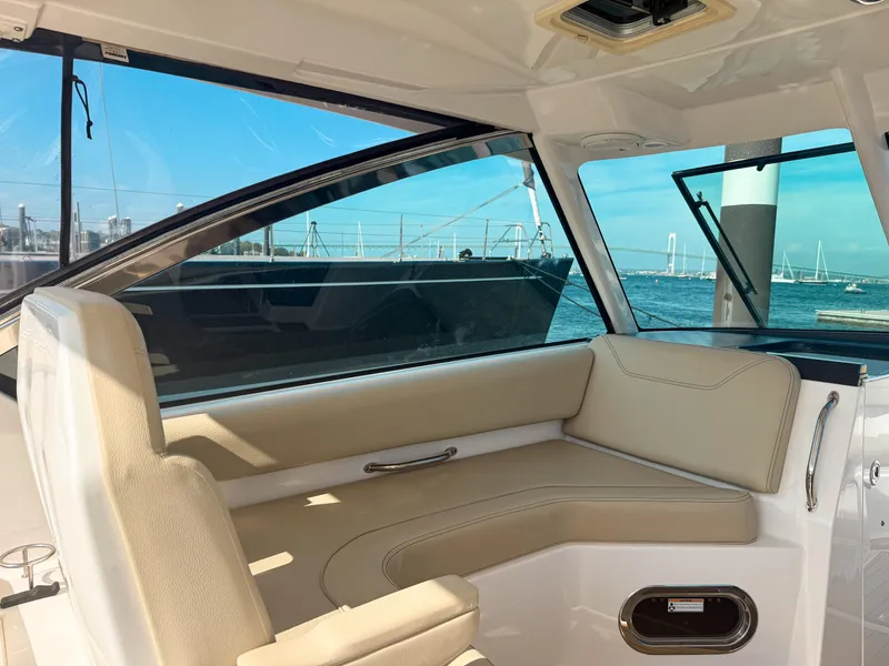 Slide: The Image of Interior of 2018 Pursuit DC 325 Dual Console boat with beige seating and ocean view. - 31