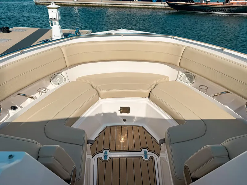 Slide: The Image of 2018 Pursuit DC 325 Dual Console boat with beige seating and teak flooring at a marina. - 34