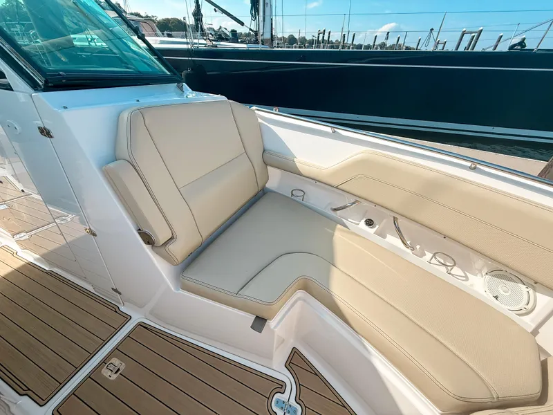 Slide: The Image of Luxurious seating on 2018 Pursuit DC 325 Dual Console boat, featuring beige upholstery and teak flooring. - 39