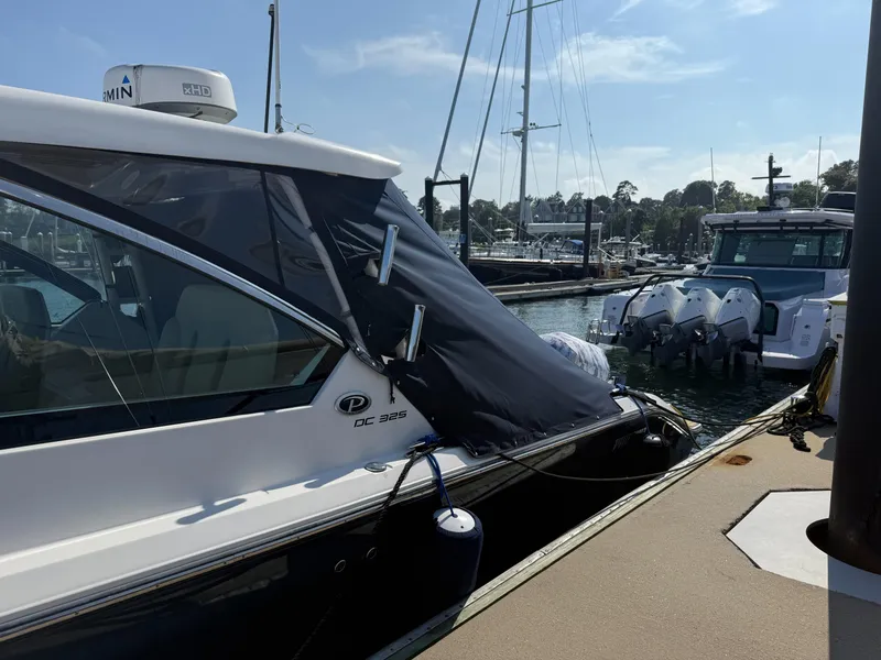 Slide: The Image of 2018 Pursuit DC 325 Dual Console boat docked at marina, sunny day. - 4