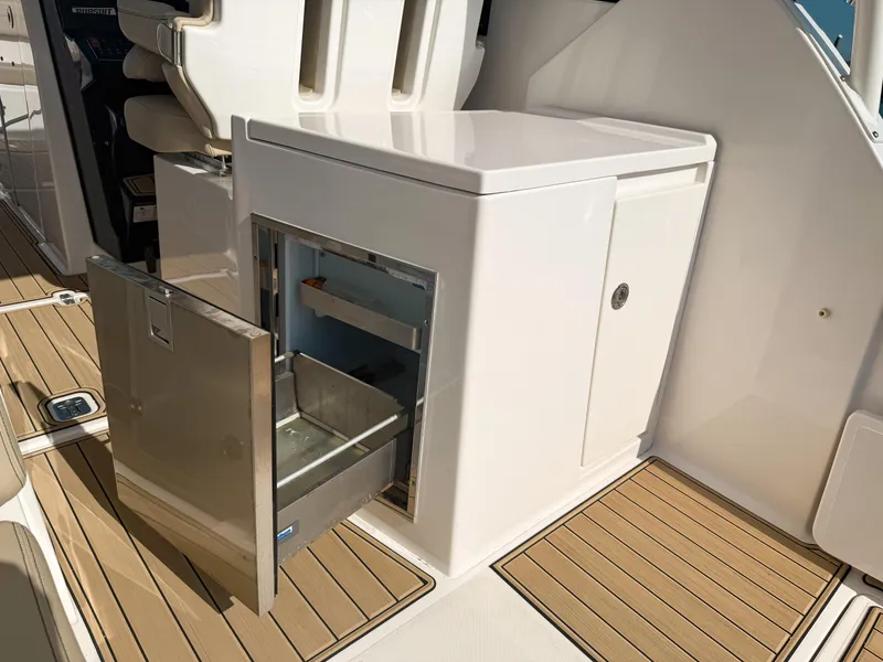 Slide: The Image of 2018 Pursuit DC 325 Dual Console boat with open storage compartment on deck. - 48
