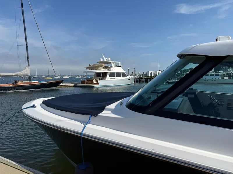 Slide: The Image of 2018 Pursuit DC 325 Dual Console boat docked in a marina with other vessels. - 5