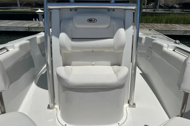 Slide: The Image of 2019 Sea Hunt Ultra 225 boat interior with white seating and console. - 11