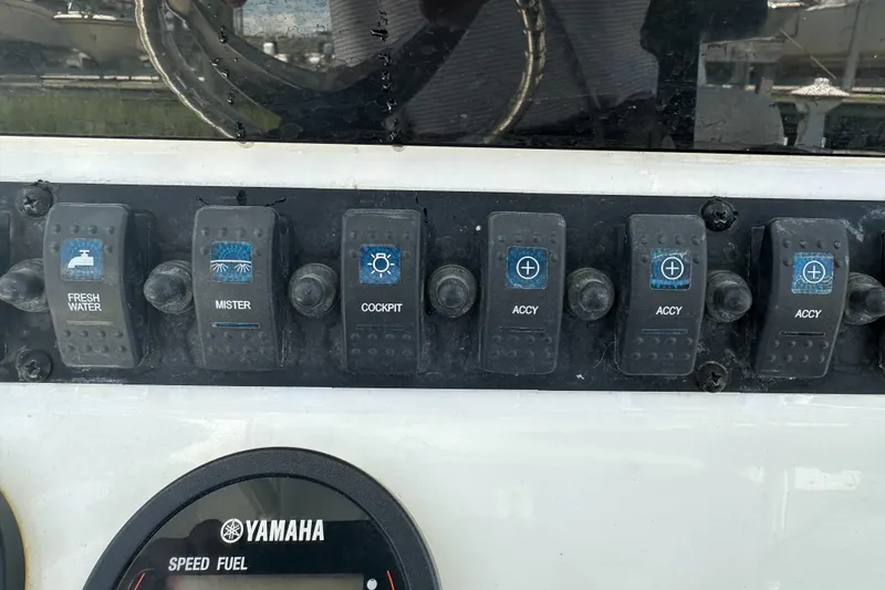 Slide: The Image of Control panel of a 2019 Sea Hunt Ultra 225 boat with various switches and Yamaha gauge. - 17