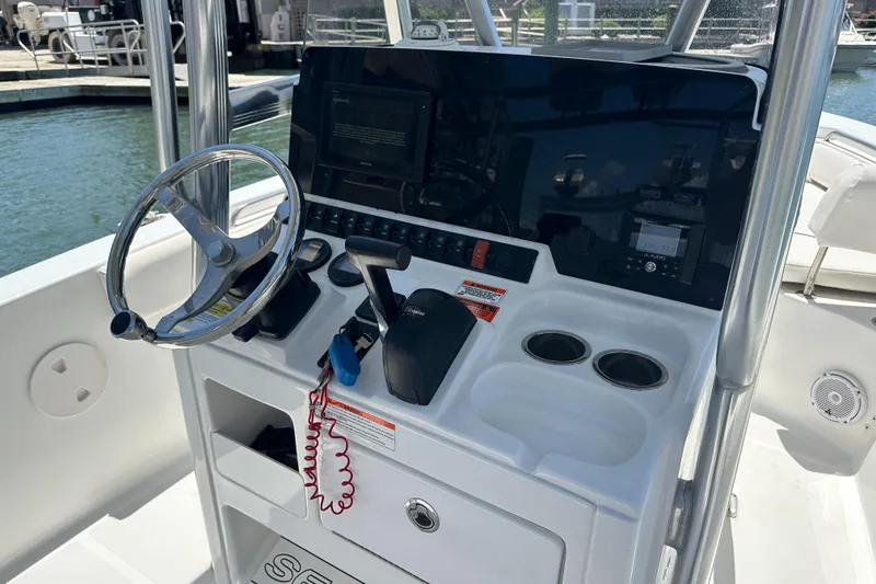 Slide: The Image of 2019 Sea Hunt Ultra 225 boat console with steering wheel and controls. - 19