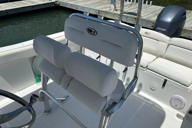 Slide: The Image of 2019 Sea Hunt Ultra 225 boat interior with white seating and steering wheel. - 25