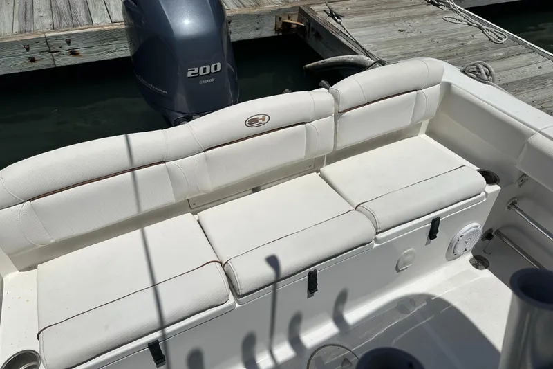 Slide: The Image of 2019 Sea Hunt Ultra 225 boat with Yamaha 200 engine, docked, featuring white seating. - 27